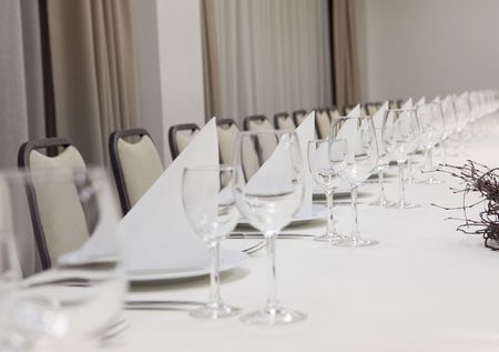 empty wine glasses on long restaurant tableの写真素材