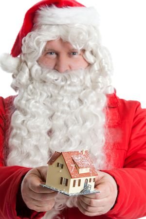 funny Santa Claus giving as small house a Christmas giftの写真素材
