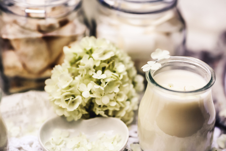 On the table are white candles and tender flowers.の写真素材