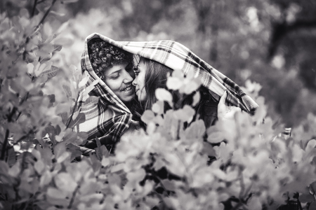 happy merry couple is hiding behind plaid autumn day. Don't worry, be happyの写真素材