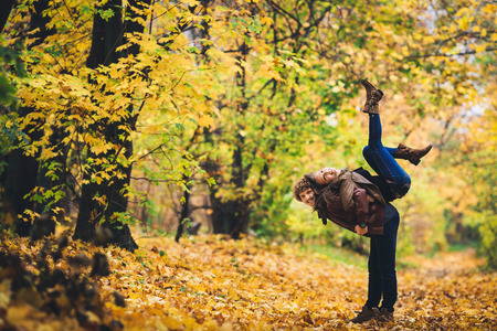 young couple fooling around in autumn parkの写真素材