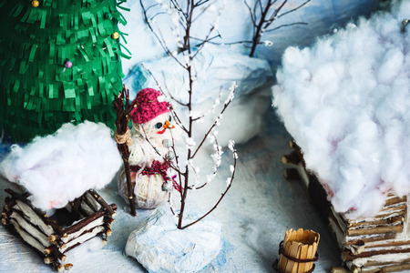 Children's crafts of the winter yard in the snow: house, trees, well, snowmanの写真素材