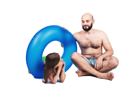 Happy bearded father and little girl with inflatable circle isolated on white background. summer holiday conceptの写真素材