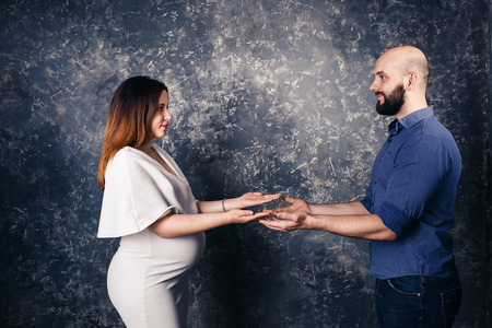 Young pregnant couple holding copyspace on the palmの写真素材