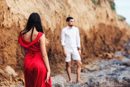 beautiful woman and bearded man posing on the background of a clay rockの写真素材