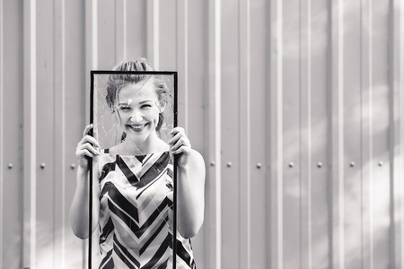 Beautiful teen girl holding broken glass in her hands. concept feminismの写真素材