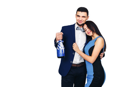 young happy stylish couple in blue clothes and with a decorated bottle of champagne or wine. isolated on whiteの写真素材