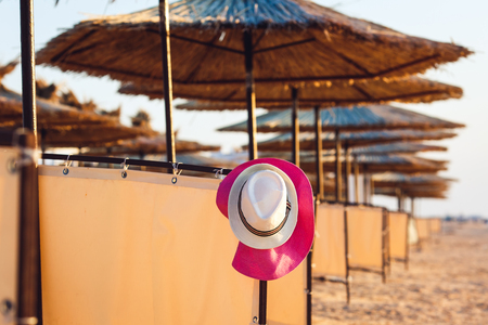 beach hat hanging among beach umbrellasの写真素材