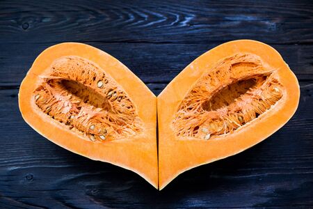 Two halves of pumpkin lie together and form heart shape.の写真素材
