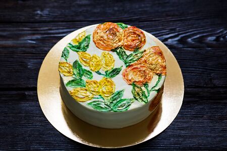 delicious sweet cake decorated with painted oranges and lemons. cake on dark wooden background.