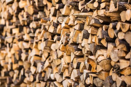 background stack of chopped firewood side view.の写真素材
