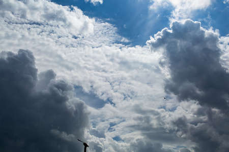 blue sky with heavy cumulus clouds and bird silhouettes