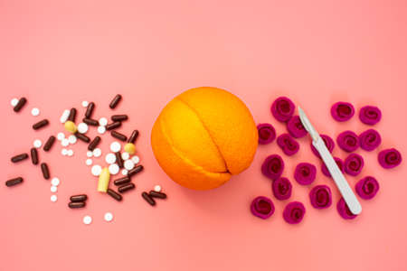 orange like a vagina, scalpel, pills on a pink background. concept of prevention and treatment of gynecological diseasesの写真素材