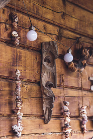 Amulets on rope hang on wooden wall of house.の写真素材