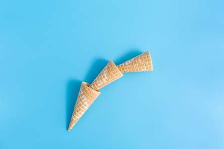 Three sweet crunchy empty ice cream wafer cups on a blue backgroundの写真素材
