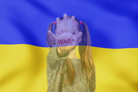 Against blue and yellow background, girl shows her palm with word war, calling for an end to aggression against Ukraineの写真素材