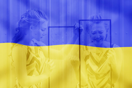 a sad girl on a blue-yellow background holds broken glass as a symbol of the war in Ukraineの写真素材