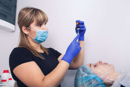 beautician draws a drug for mesotherapy into a syringe.