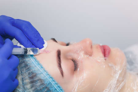 The cosmetologist makes an injection of mesotherapy. Mesotherapy with microneedles for facial skin rejuvenation.の写真素材