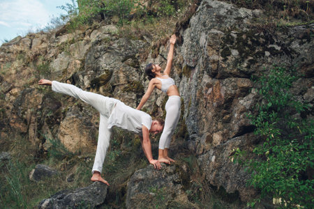 young couple doing yoga outdoors. Healthy lifestyle concept.の写真素材