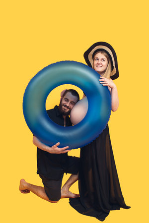 the bearded man listens to the belly of his beautiful pregnant wife and smiles. Pregnant couple with...