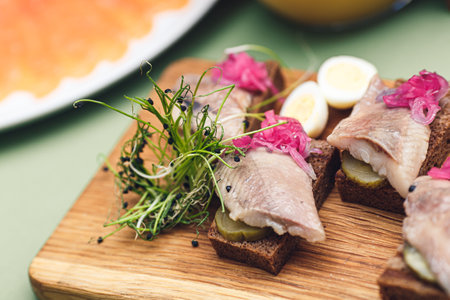 Black bread sandwich with herring, pickled cucumber and microgreensの写真素材