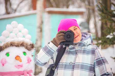 girl with camera in winter, in the city Park at the festivalの写真素材