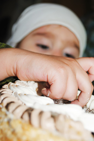 the child eats a cake with his hands, in the village of his grandmotherの写真素材