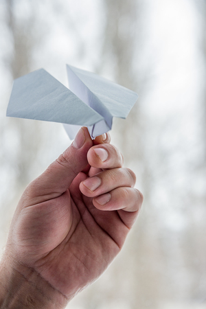 paper airplane in his hand on the window background, the concept of flightの写真素材