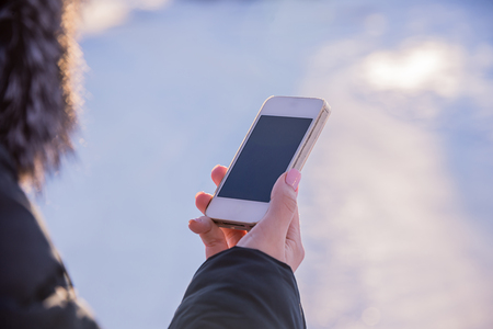 the girl looks into the phone, looking for contacts, texting, talking about businessの写真素材