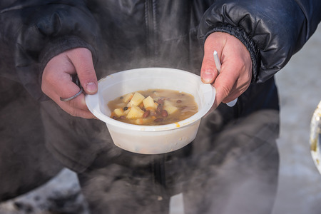 feeding homeless people on the street, social problems, hungry people eatの写真素材