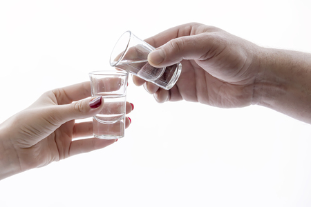 men's and women's hand holding glasses of alcoholの写真素材