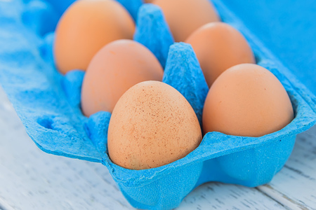 yellow eggs in a blue tray closeup