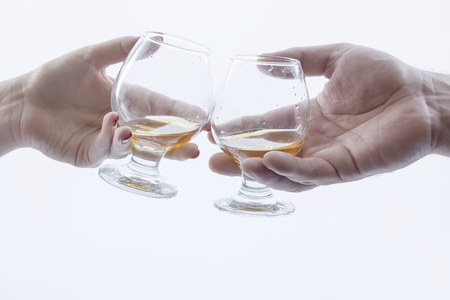 men's and women's hand holding glasses of alcoholの写真素材
