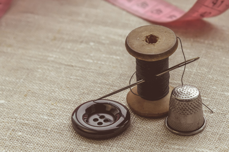 the composition of the seamstress, the tailor, the sewing thread and for knitting, the gray thread and the needle and the buttonの写真素材