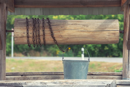 The old well for water with a deck, a bucket and a chain,の写真素材