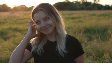 portrait of a beautiful girl straightening her hair against the background of autumn nature.