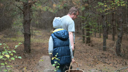 a lonely man with his daughter walks through a dark forest in search of mushrooms.の写真素材