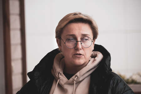 girl with short hair wearing glasses in the wind autumn portrait tinted.の写真素材