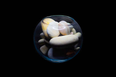 beautiful sea stones in a small aquarium on a black background.の写真素材