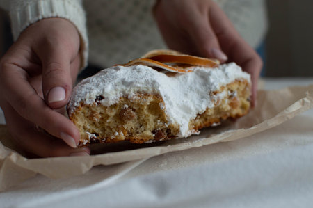 A woman's hands hold a Christmas cake with powdered sugar. New Year and Christmas. Close-up.の写真素材