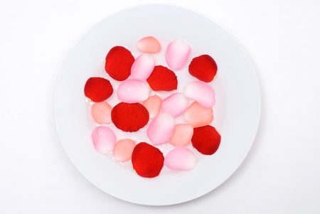 Rose petals floating on the water poured plate