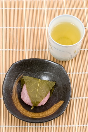 Japanese rice cake(doumyouji rice flour) covered with sweetened bean jam wrapped in a preserved cherry leaf named Doumyouji-sakuramochi(West style sakuramochi)の写真素材