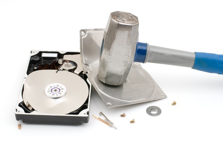 Hammer destroying hard disk drive on a white background