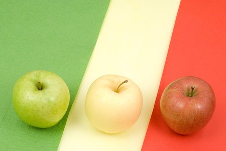 Three types apple on the bright color paperの写真素材