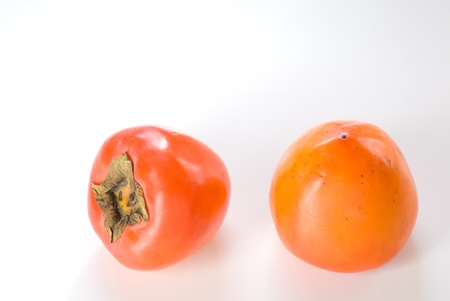 Two astringent persimmons isolated on white backgroundの写真素材