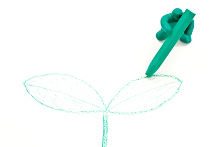 Clay doll draw a seed leaf with crayon isolated on white backgroundの写真素材