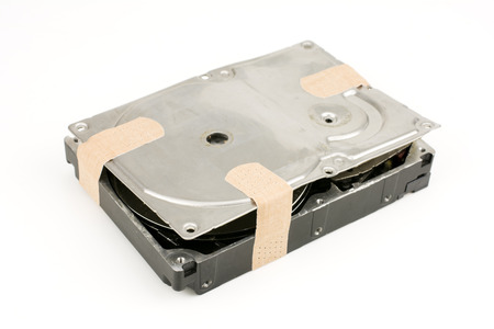 Damaged hard disk drive put a adhesive plaster isolated on white background