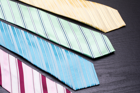 Four lined colorful ties on black tableの写真素材