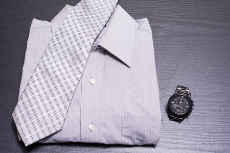 Shirt with tie and watch on black deskの写真素材